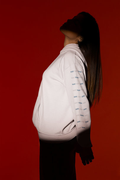 Gildan Hoodie Mockup Featuring a Woman Posing Under a Spotlight