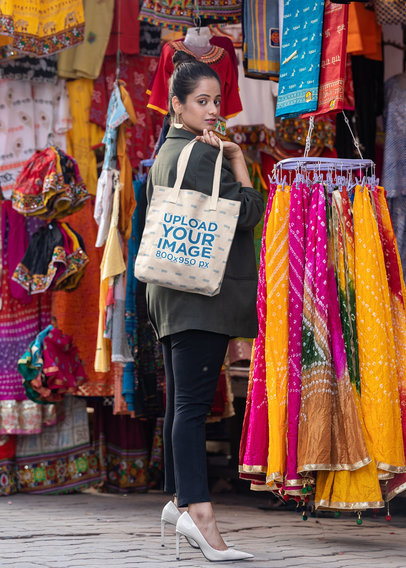 Mockup of a Woman Holding a Tote Bag in a Market 