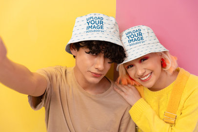 Bucket Hat Mockup of a Serious Man and a Smiling Woman Taking a Selfie in a New Pop Wave Setting