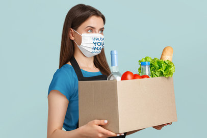 Face Mask Mockup of a Woman with a Box of Groceries in a Studio