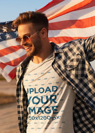 T-Shirt Mockup of a Stylish Man Holding an American Flag