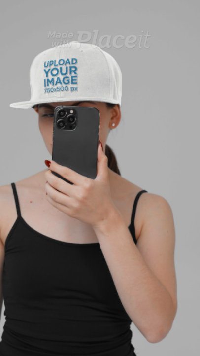 Snapback Hat Video Featuring a Woman Taking a Selfie in a Studio