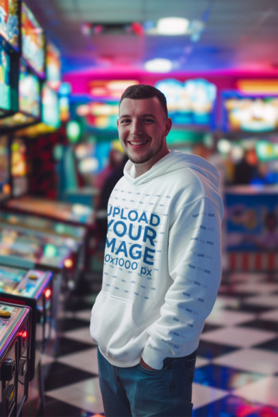 Pullover Hoodie Mockup Featuring an AI-Created Happy Man Standing in a Game Arcade
