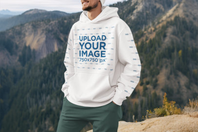 Pullover Hoodie Mockup of an AI-Created Cheerful Man Posing on the Top of a Mountain