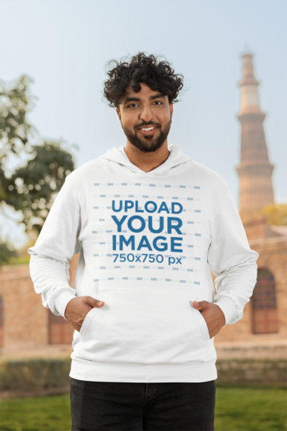 Gildan Pullover Hoodie Mockup of a Happy Bearded Man Standing Near a Historical Building