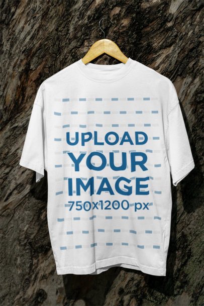 Mockup of an Oversized T-Shirt Placed on a Hanger by Tree Log