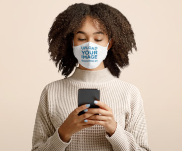 Face Mask Mockup of a Woman Checking Her Phone in a Studio