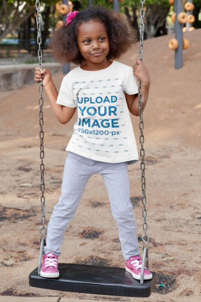 T-Shirt Mockup of a Playful Girl Standing on a Swing